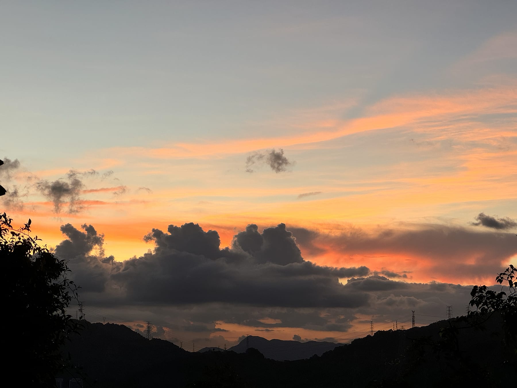 橙色晚霞越过深色山影与云层
